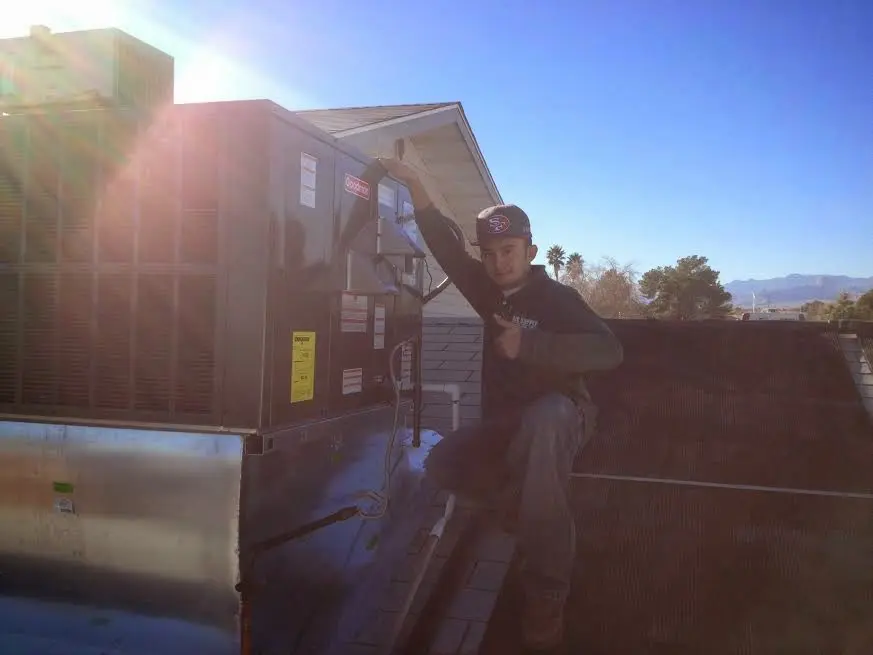 HVAC technician performing Boiler Repair on a rooftop unit in Paragould